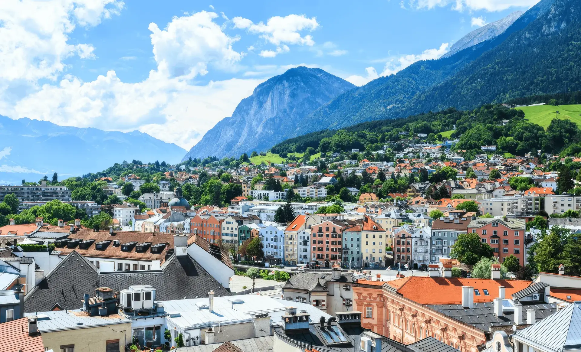 View over the rooftops of Innsbruck in summer with the surrounding mountains