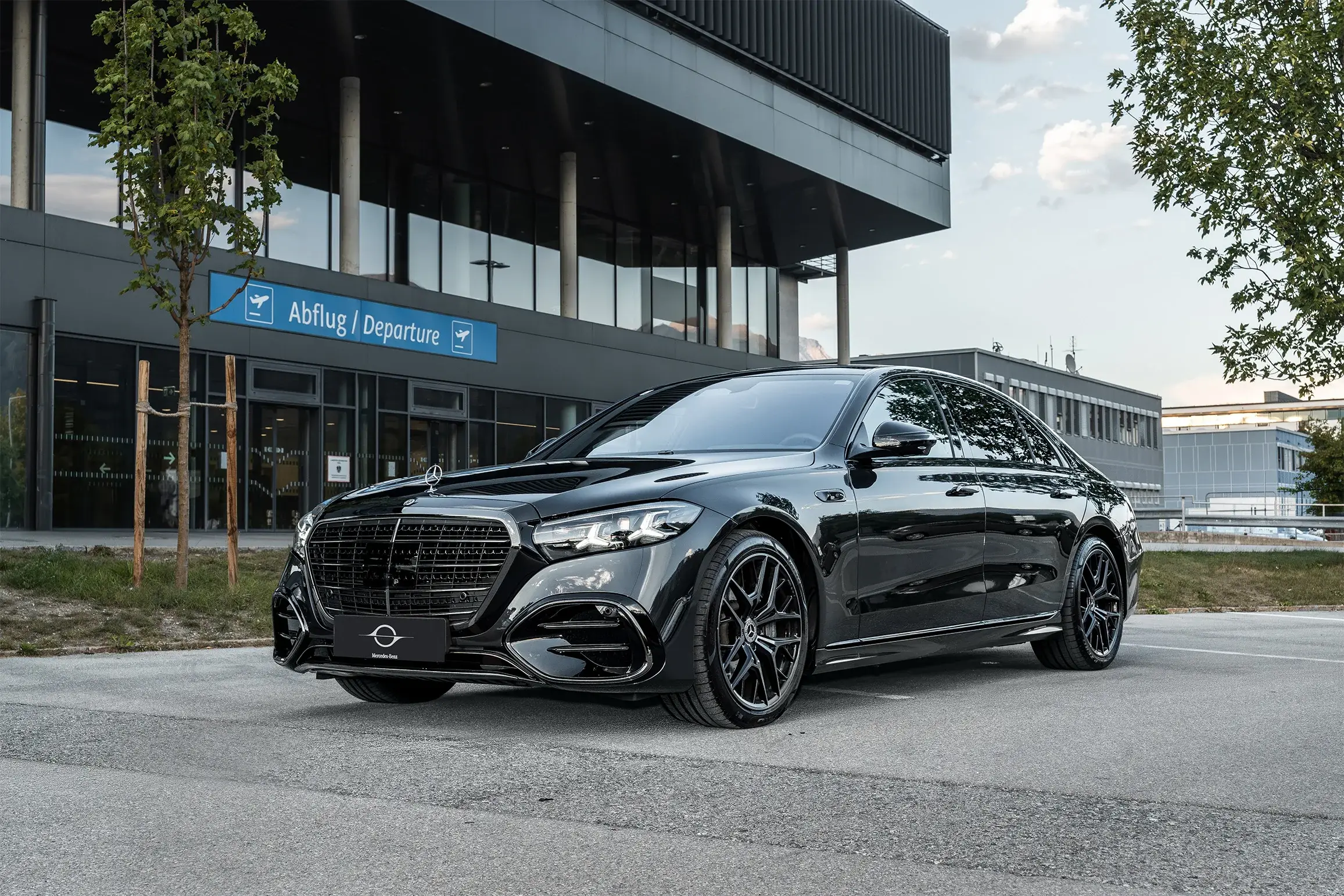Zwarte Mercedes S-Klasse voor de vertrekhal van de luchthaven Innsbruck
