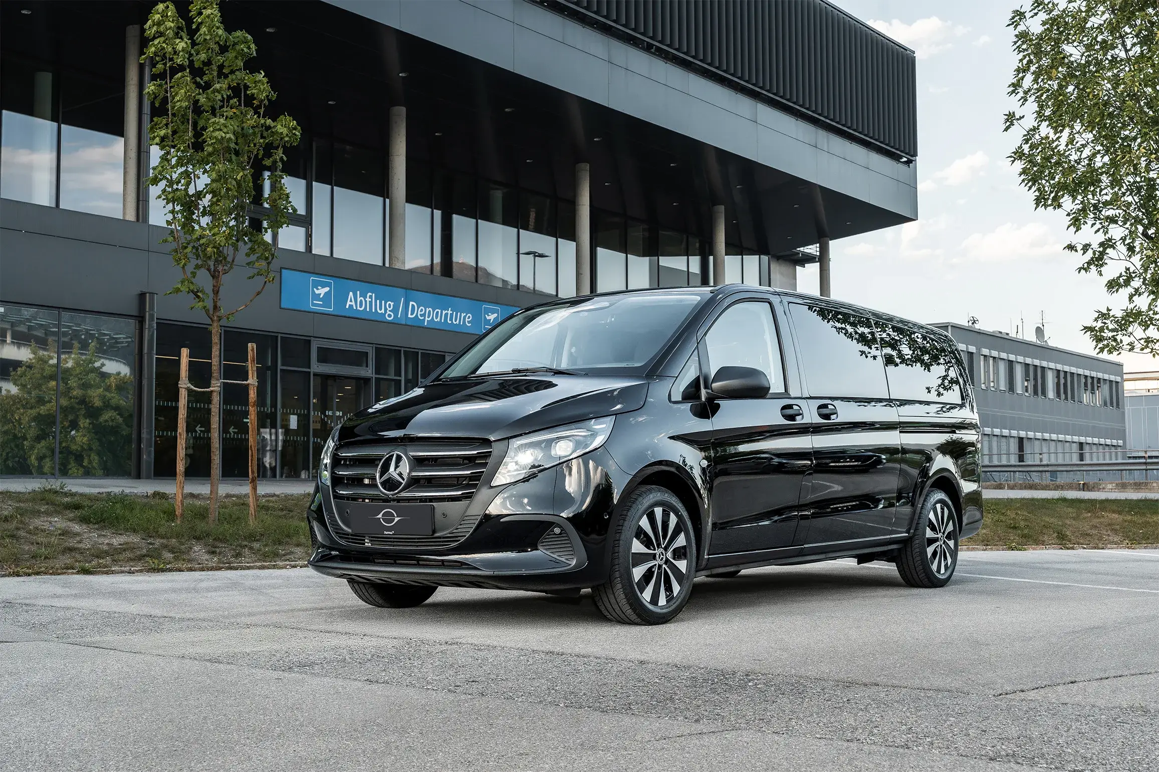 Black Mercedes Vito in front of the departures area at Innsbruck Airport
